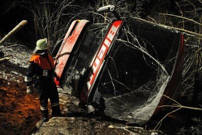 Ein Feuerwehrmann steht nahe Stallwang (Niederbayern) neben einem umgekippten Bus. Bei dem Busunfall sind 15 Menschen teilweise schwer verletzt worden. (FOTO: DPA)