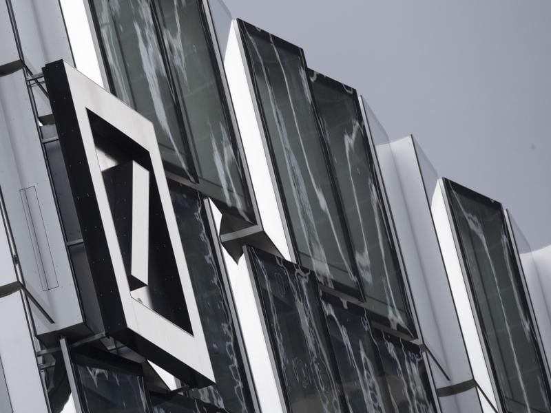 Das Logo der Deutschen Bank an einem Gebäude. Foto: Boris Roessler/dpa/Archivbild