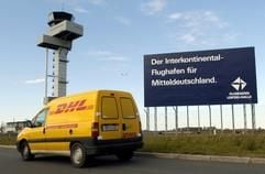 Ein Fahrzeug des Kurierdienstes DHL fährt am Tower des Mitteldeutschen Flughafens Leipzig/Halle in Schkeuditz vorbei. (Foto: dpa)