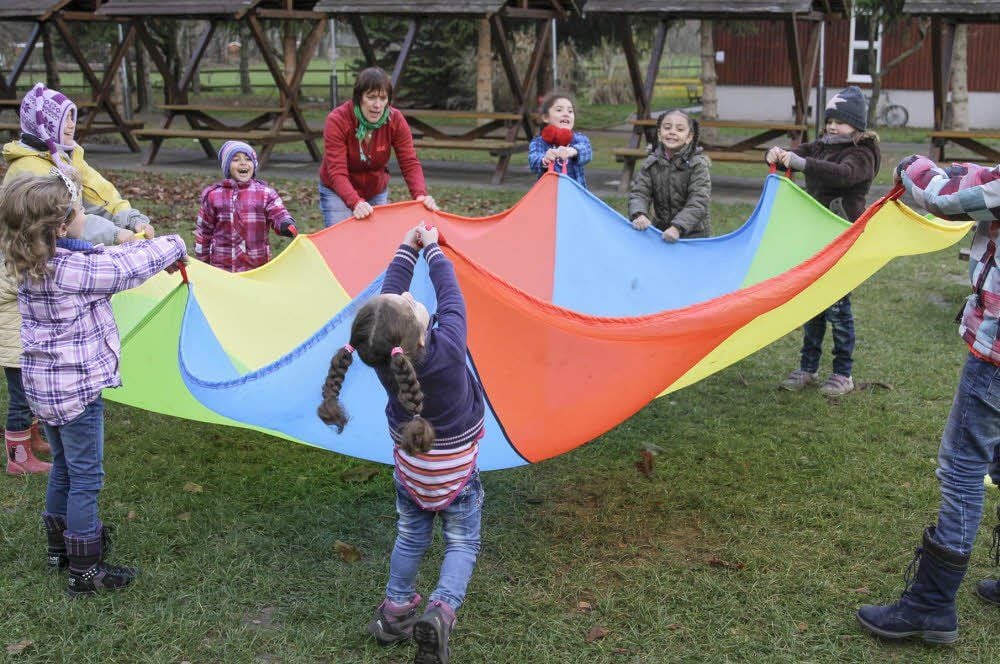 Veronika Eisenschmidt lernt mit Kindern spielerisch die Farben des Schwungtuches und das Zählen.