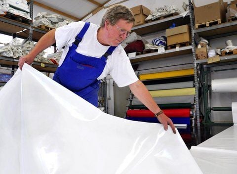 Sattler Michael Hartwig beim Zuschneiden einer Plane für ein Zelt. (FOTO: ENGELBERT PÜLICHER)