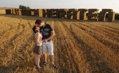 Markus Schmidt küsst seine Verlobte Corinna Pesl vor den aus Strohballen errichteten Worten "Willst mich heiraten". (FOTO: DPA)
