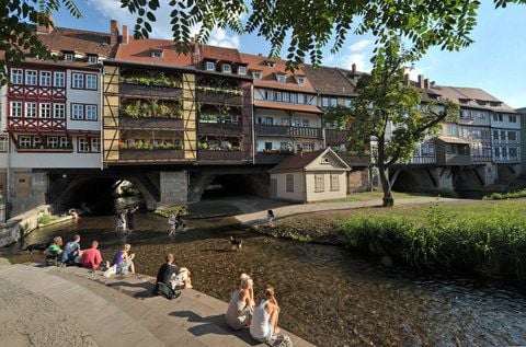 Touristen und Einheimische sitzen an der Krämerbrücke in Erfurt. (FOTO: DPA)
