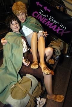 Mit Reiseutensilien ausgerüstet und scheinbar barfuß warten die Geschwister Ramona (l) und Bianca (r), verkleidet als Ringträger Frodo und dessen Gefährten Sam, am Dienstag (16.12.2003) in einem Kino in Hamburg auf den Beginn des letzten Teils der "Herr der Ringe"-Triologie. (Foto: dpa)