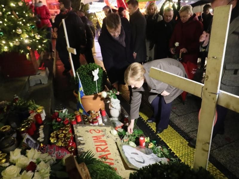 Angela Merkel legt eine weiße Rose zum Andenken an die Opfer des Terroranschlags am Breitscheidplatz in Berlin nieder. Foto: Michael Kappeler
