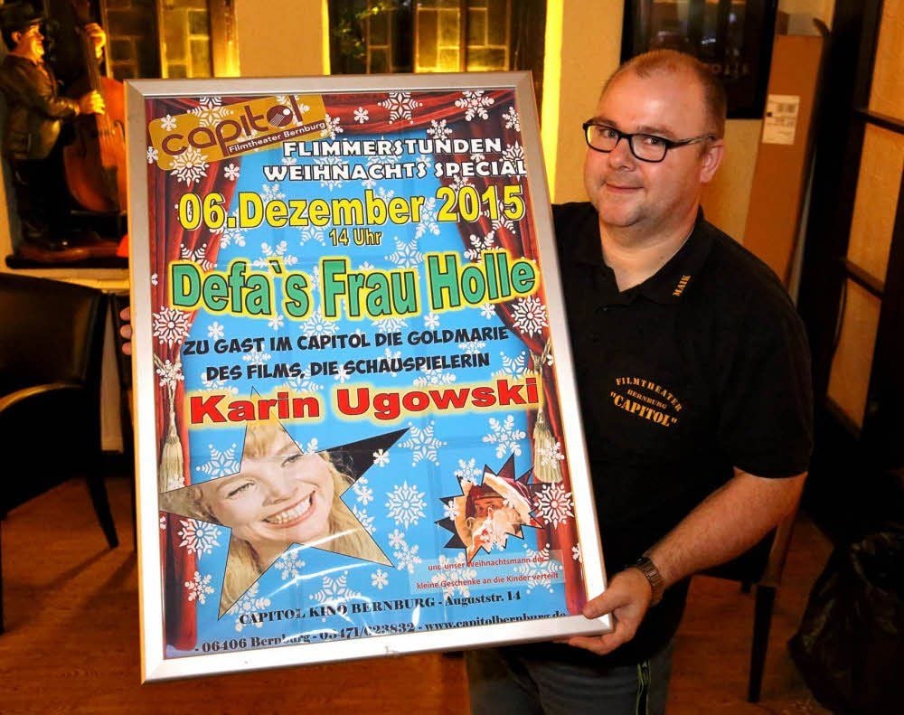 Kinomitarbeiter Maik Erdmann hält das Plakat für die Märchenvorstellung in der Hand.