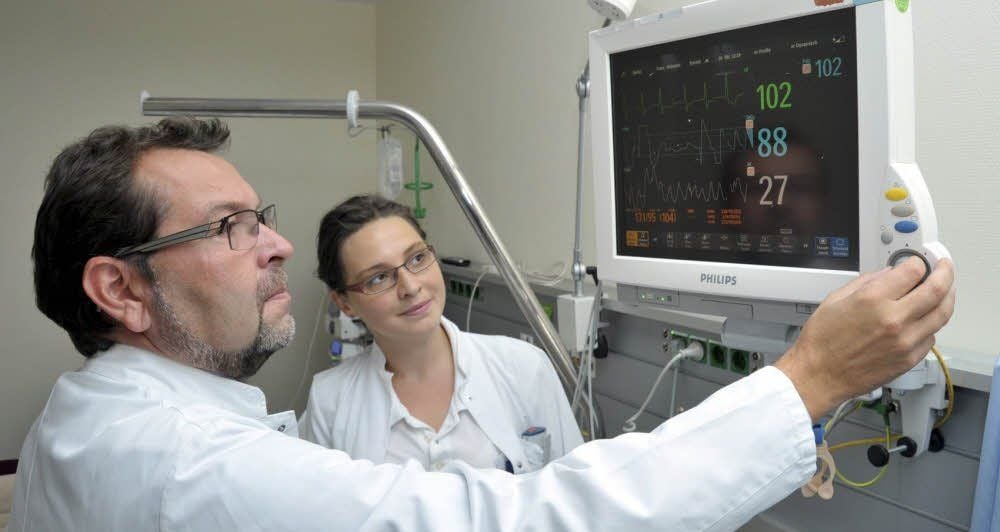 Chefarzt Steffen Eue informiert sich mit Assistenzärztin Laura Millig am Überwachungsminitor über die Vitalfunktionen einer Patientin.