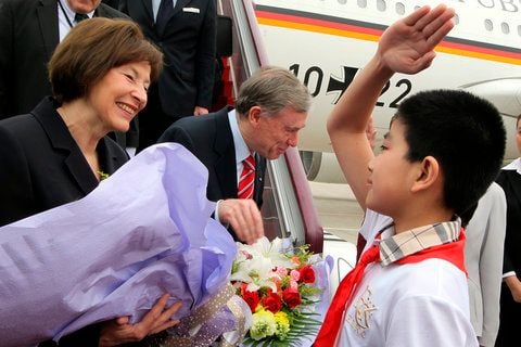 Mit einem Pioniergruß heißen chinesische Schüler am Montag auf dem Flughafen von Peking Bundespräsident Horst Köhler und seine Frau Eva Luise willkommen und überreichen Blumensträuße. (FOTO: DPA)