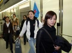 Eine Fahne mit einem roten Stern in der Mitte trägt am Samstag in der Ankunfthalle des Flughafens Tegel in Berlin eine chinesische Reiseleiterin. (Foto: MZ)