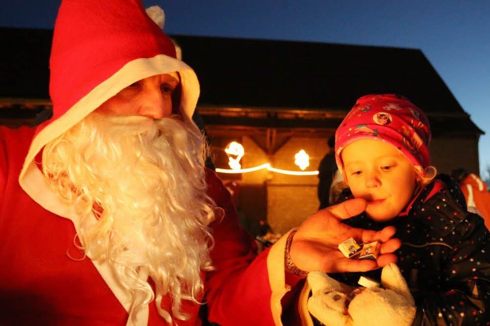 Die kleine Amalia (rechts) aus Gatersleben bekommt Süßes vom Weihnachtsmann