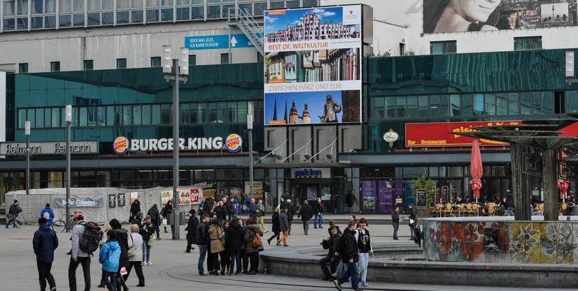 Mit diesem Plakat wirbt Sachsen-Anhalt auf dem Alexanderplatz in Berlin für sich. Das mittlere Motiv zeigt Fachwerkhäuser in Quedlinburg.