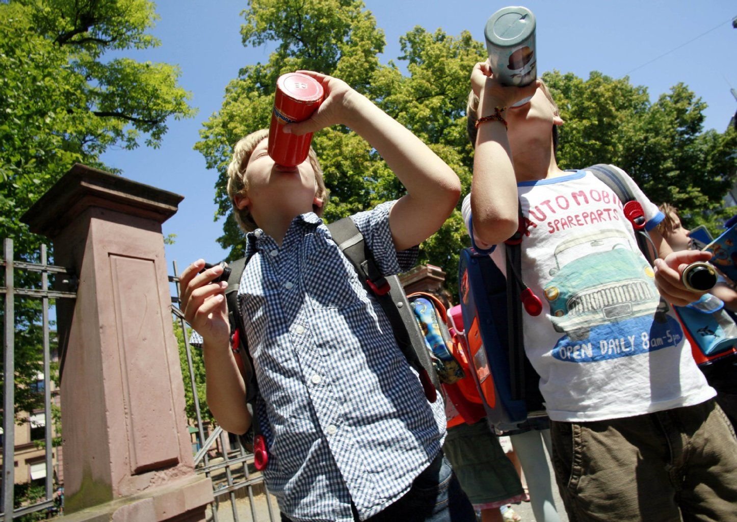 Die beiden Jungen gönnen sich vor einer Grundschule erst einmal einen Schluck aus der Wasserflasche. Zum ersten Mal in diesem Jahr gab es für einige Schüler Hitzefrei.