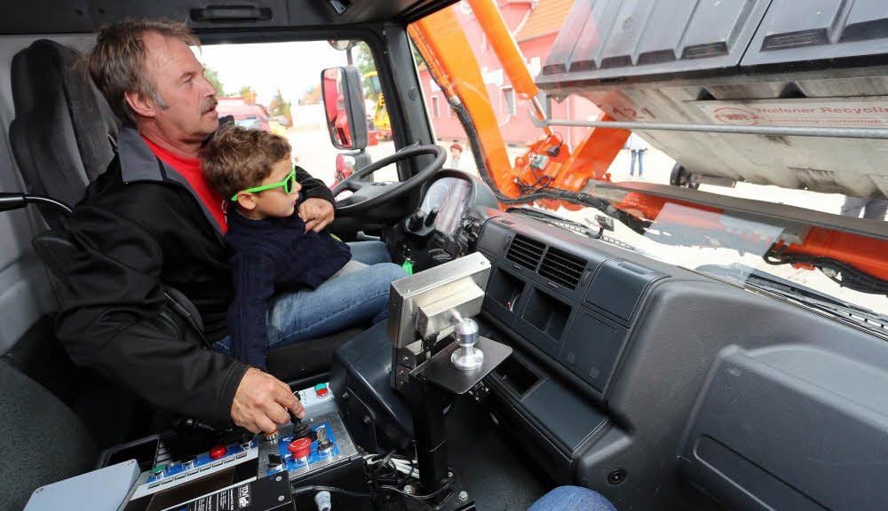 Auch der kleine Besucher Mattheo darf einmal ein Müll-Umleerfahrzeug bedienen. Der Fahrer Lutz Höppner zeigt ihm, wie das geht.