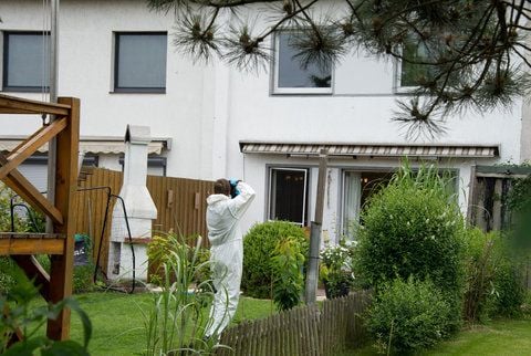 Ein Ermittler in weißem Anzug fotografiert am Freitag in Groß Ilsede bei Peine das Reihenhaus, in dem vier Kinder zu Tode kamen. (FOTO: DPA)
