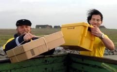 Postschiffer Fiede Nissen (l.) legt am Dienstag (05.12.2006) zusammen mit seinem bayerischen Kollegen Andreas Oberauer auf der Hallig Gröde die Halligpost in einen Hänger. (Foto: dpa)