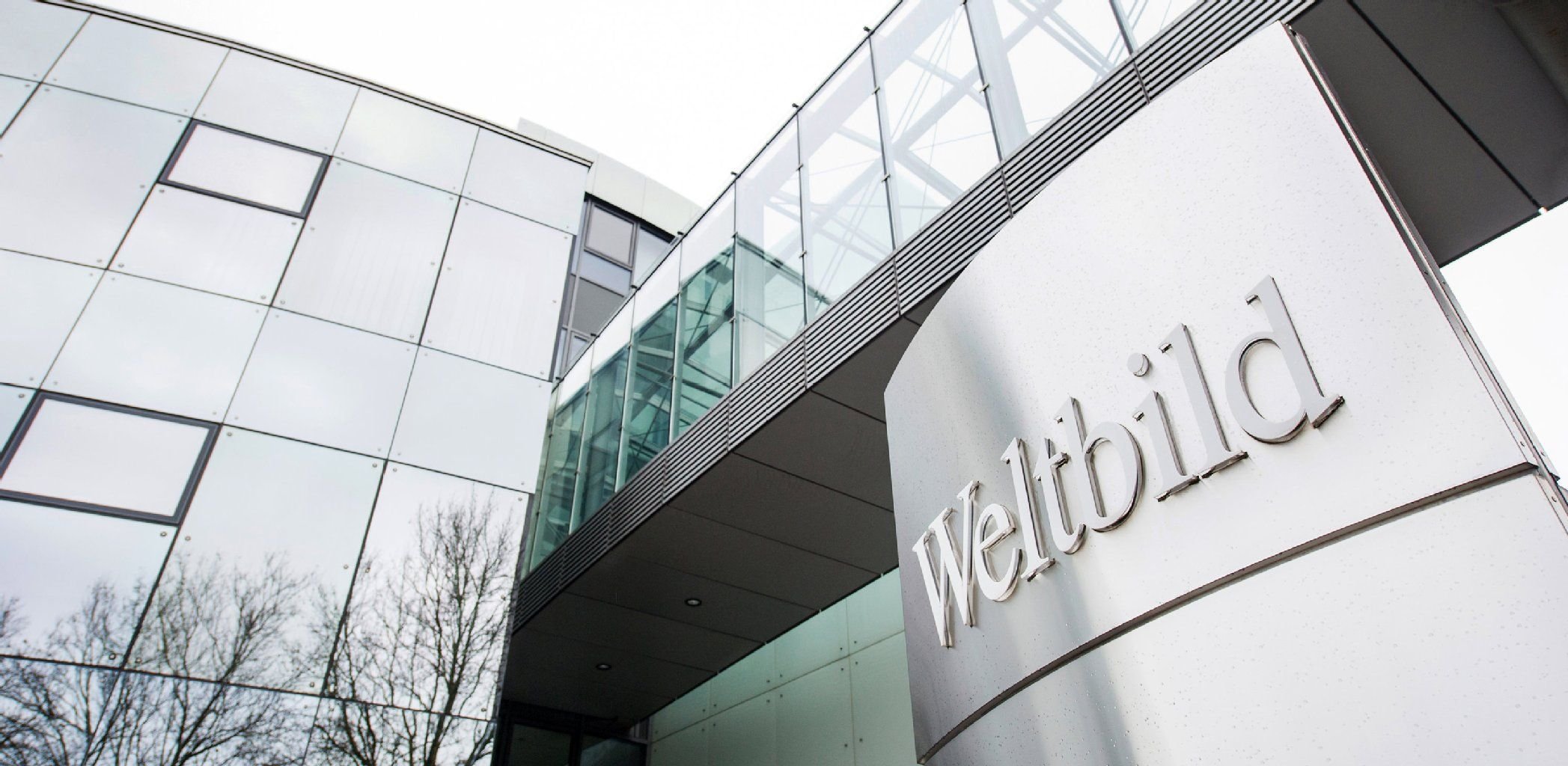 Ein Schild mit der Aufschrift "Weltbild" ist am in Augsburg (Bayern) vor der Zentrale des Weltbild-Verlags zu sehen.