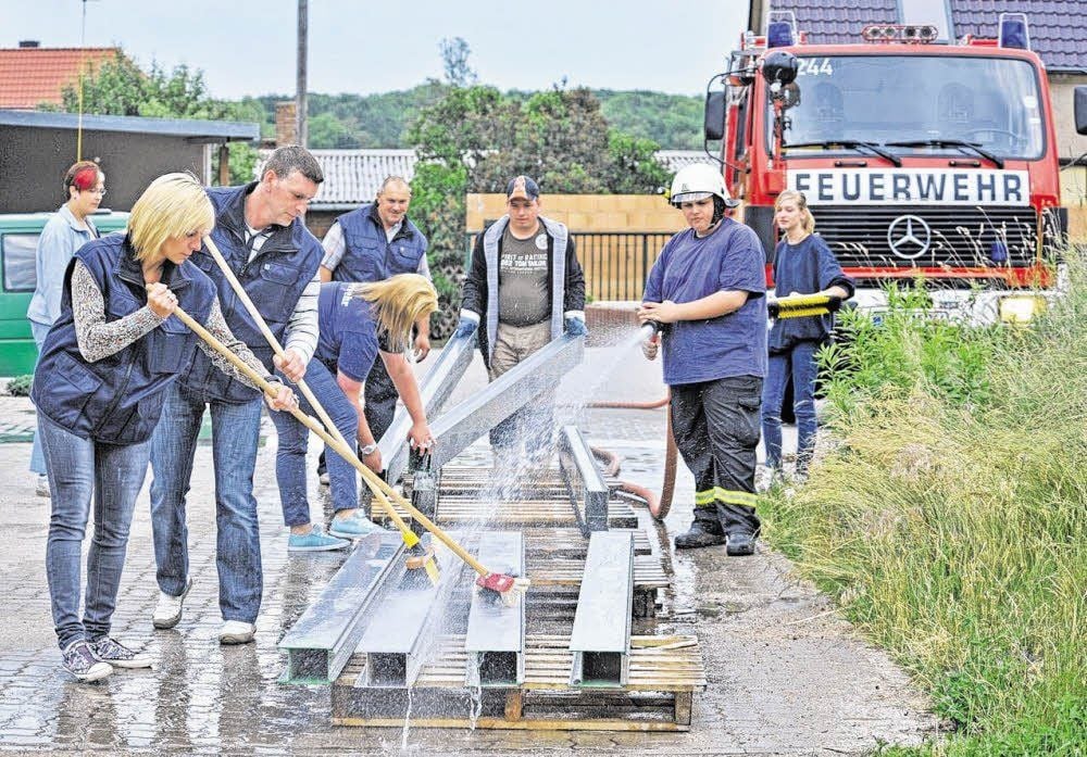 In Raguhn hilft die örtliche Feuerwehr bei der Reinigung von Teilen der Spundwände, die während des Hochwassers im Juni zum Einsatz kamen. Auf rund 100 Metern waren allein in Raguhn mobile Hochwasserschutzanlagen aufgestellt worden.