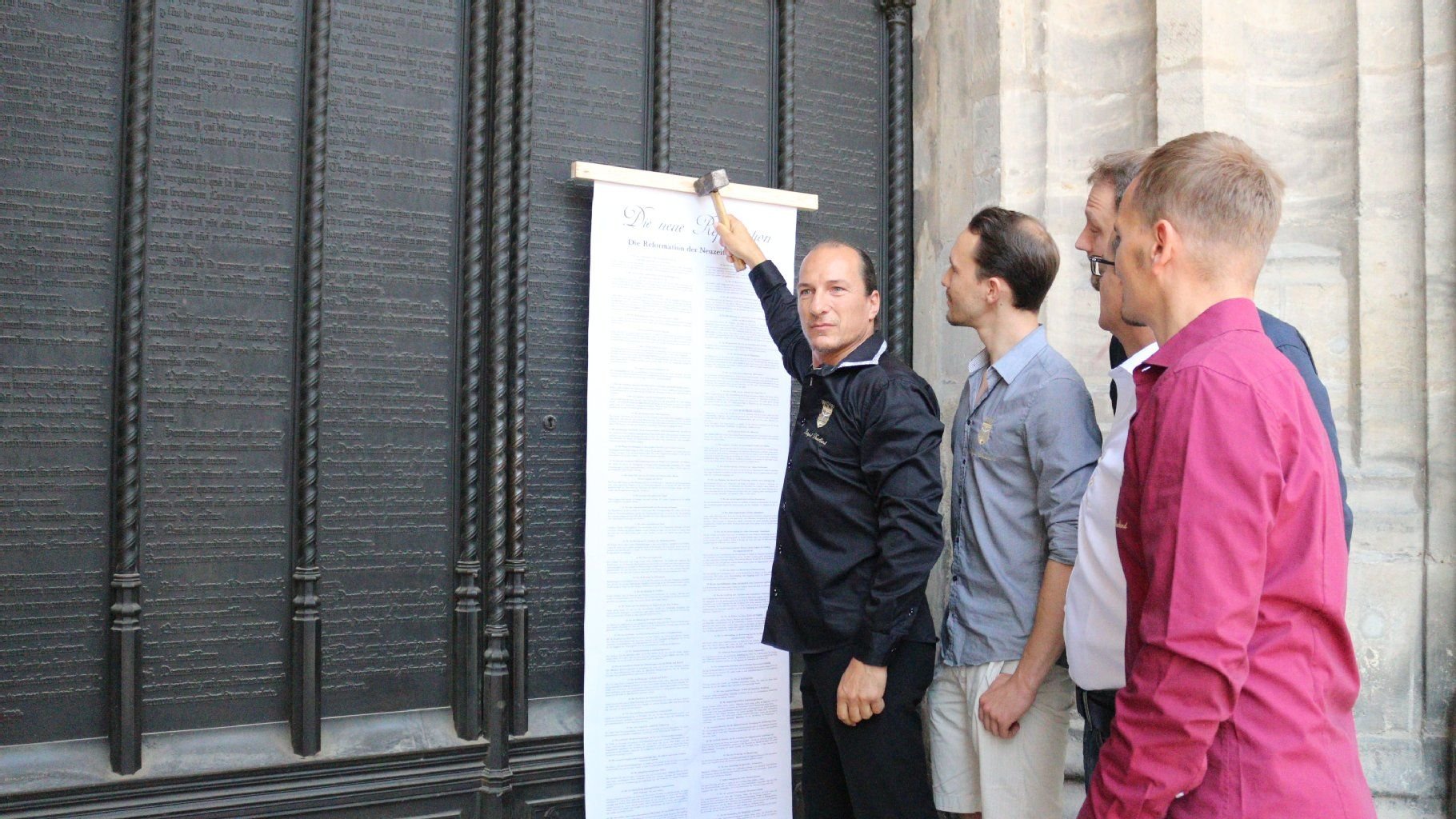 Peter Fitzek mit seinen 77 Thesen an der Thesentür der Wittenberger Schlosskirche.