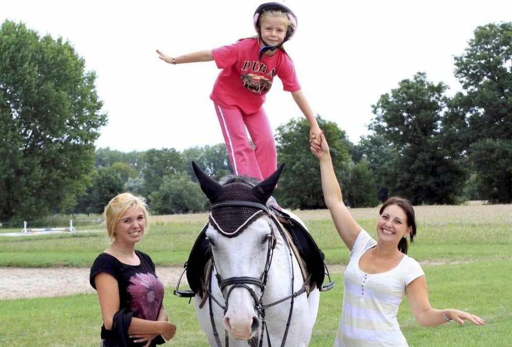 Melanie Hildebrandt (links) und Julia Hobusch (rechts) helfen Blia auf dem Pferd.