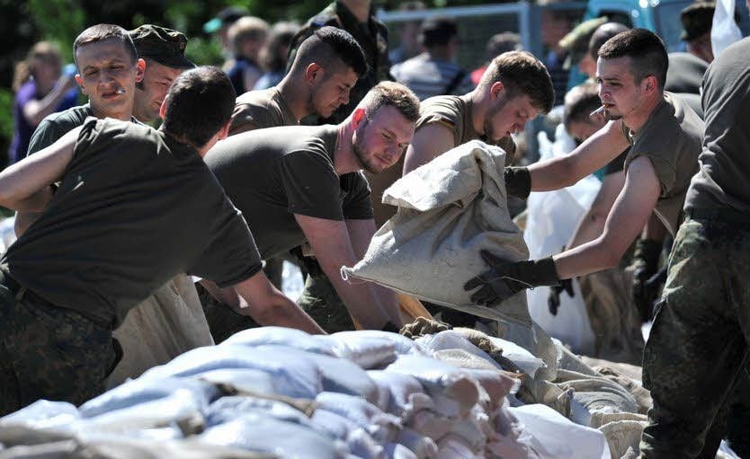 170 Bundeswehrsoldaten errichten am Stadtstrand von Bitterfeld einen Sandsackdeich.