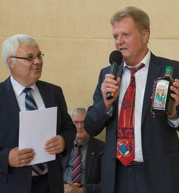 Schulleiter Detlef Reimann (rechts, mit Urkunde) bekam vom stellvertretenden Direktor des Landesschulamtes, Jürgen Krampe, die Ernennungsurkunde zum Gemeinschaftsschulrektor und eine kleine Flasche Kräuterschnaps überreicht.