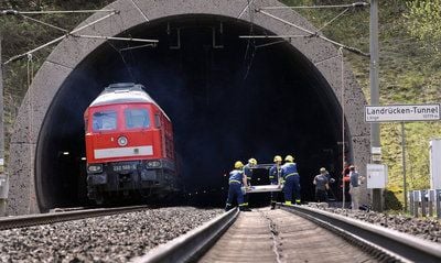 Mitarbeiter des Technischen Hilfswerkes heben am 28.04.08 am Eingang des Landrücken-Tunnels bei Kalbach einen Materialwagen von den Schienen. (FOTO: DDP)