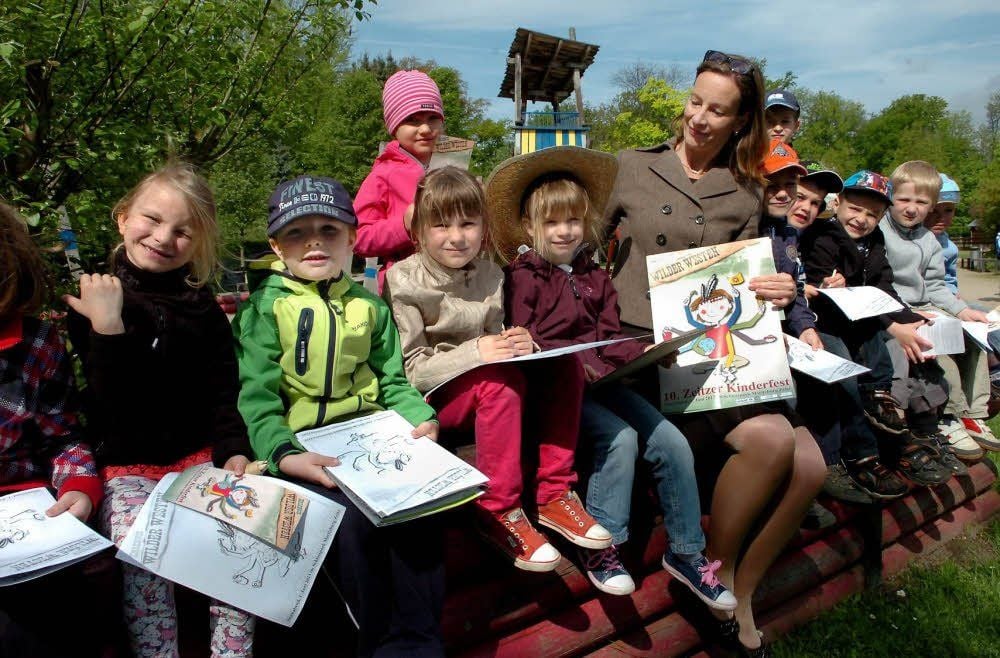 Silke Lorenz, Sparkasse Burgenlandkreis, übergibt den Kindern der katholischen Kindertagesstätte Malvorlagen für das Kinderfest.
