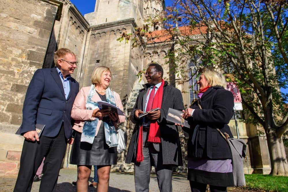 Gemeinsam mit dem SPD-Bundestagsabgeordneten Karamba Diaby (2.v.r.) und Kreisrätin Manuela Hartung (r.) lässt sich Bundes-Finanzstaatssekretärin Bettina Hagedorn von Holger Kunde über die Reinigung der Dom-Fassade informieren.