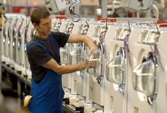 An einer Produktionsstraße für Waschautomaten arbeitet ein Miele-Mitarbeiter in Gütersloh. (Foto: dpa)