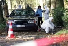 Polizeibeamte der Spurensicherung untersuchen am Donnerstag (21. Oktober 2004) am Deichsee in Quakenbrück (Kreis Vechta) den Tatort eines Mordfalles. Im der Bildmitte steht ein Taxi, deren Fahrerin in den frühen Morgenstunden tot im See aufgefunden worden war. (Foto: dpa)