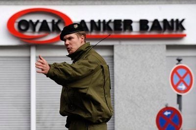 Ein Polizist regelt in Berlin vor einer Filiale der Oyak Anker Bank den Verkehr. Nach einem Banküberfall am Montagmorgen in Berlin-Kreuzberg hat ein Spezialeinsatzkommando (SEK) die Filiale gestürmt. (Foto: dpa)