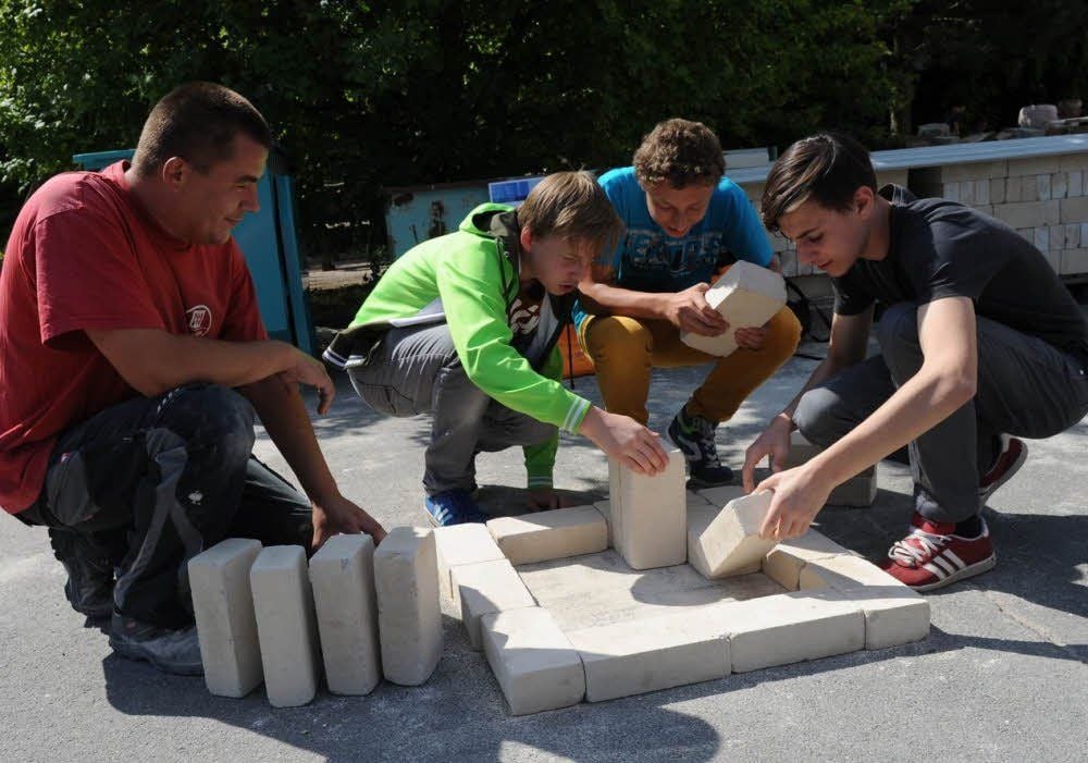 Lehrling René Freiauf schaut zu, wie sich die Eisleber Katharinenschüler am Puzzle versuchen.