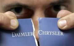 Ein Mann hält in Stuttgart ein zerrissenes DaimlerChrysler-Logo in den Händen. (Foto: dpa)