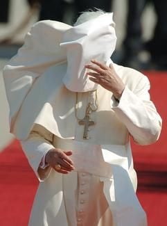 Der Kragen der Soutane von Papst Benedikt XVI wird durch den starken Wind hochgeweht und versperrt dem Oberhaupt der katholischen Kirche während seines Besuchs beim Weltjugendtag in Köln die freie Sicht (Archivfoto vom 18.08.2005). (Foto: dpa)