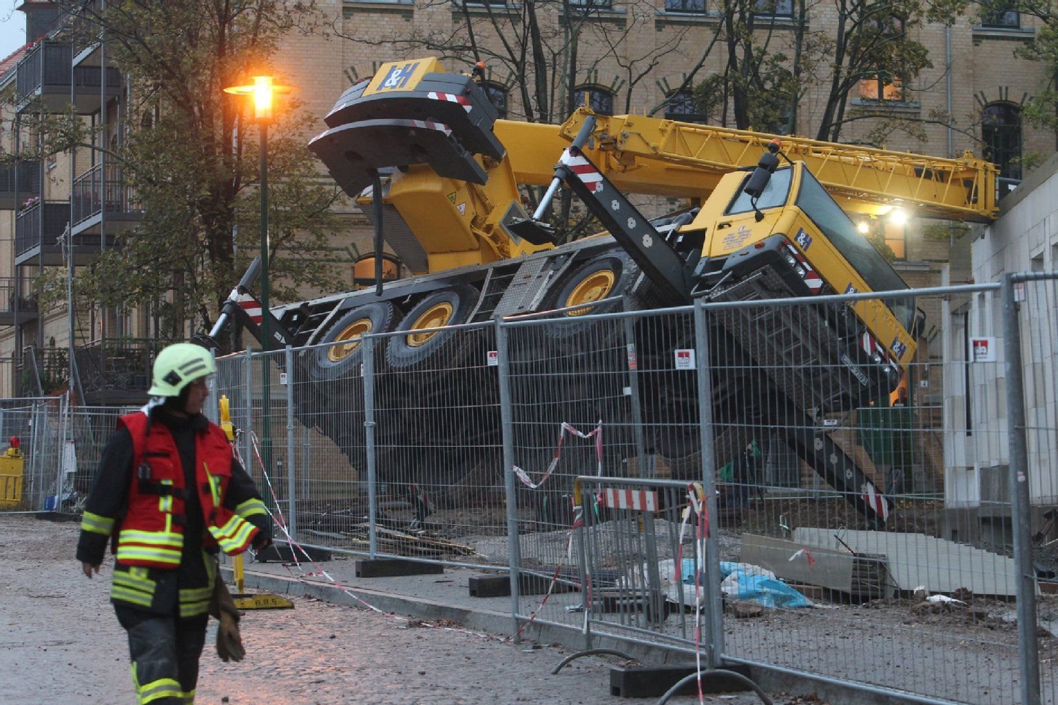 Ein umgestürzter Autokran liegt in Leipzig auf einer Baustelle. Bei dem Unglück ist ein Mann ums Leben gekommen.