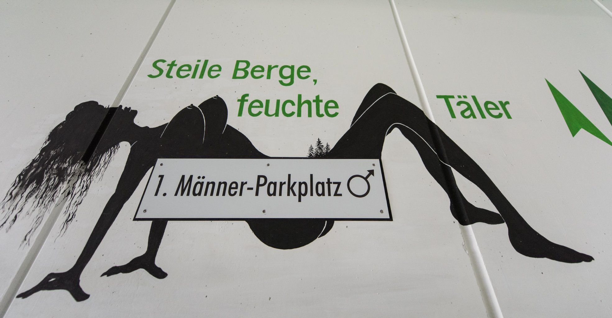 Dieser Werbegag polarisiert: Das Bild einer nackten Frau und der Spruch „Steile Berge, feuchte Täler“ prangen an der Wand des ersten Männer-Parkplatzes in Deutschland.