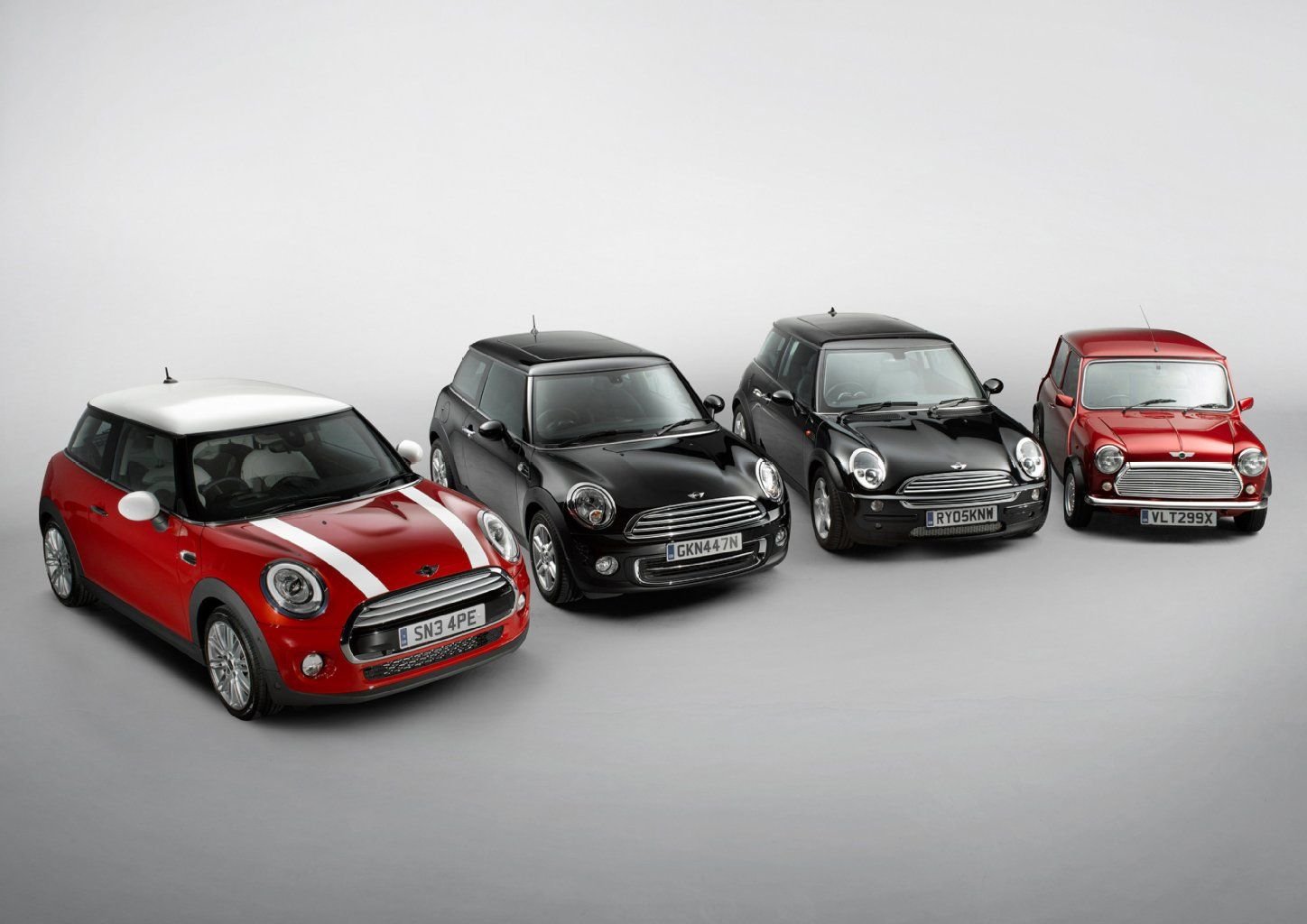 Der neue Mini (links) und seine Vorgänger. Der Mini ist seit 54 Jahren auf den Straßen und seit wird 2001 unter der Regie von BMW produziert.