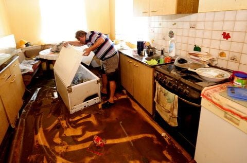 Ernst Jergler steht am 10.08.10 im ostsächsischen Hagenwerder bei Görlitz in seiner vom Hochwasser der Neiße in Mitleidenschaft gezogenen Küche und schaut in den umgestürzten Kühlschrank. (FOTO: DDP)