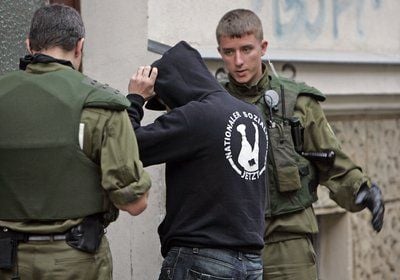 Ein Teilnehmer einer rechtsextremen Kundgebung wird von Polizeikräften kontrolliert. (FOTO: DPA)