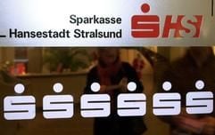 Das Logo der Sparkasse Stralsund in der Schalterhalle im Hauptgebäude des Kreditinistituts in der Hansestadt (Archivfoto vom 11.12.2003). Der Eröffnung eines Bieterverfahrens für den deutschlandweit ersten Verkauf einer Sparkasse steht nichts mehr im Wege. Das Verwaltungsgericht Greifswald hat am Dienstag (24.02.2004) einen Eilantrag abgelehnt, mit dem PDS-Abgeordnete die Stadt Stralsund bis zur Entscheidung über die Zulässigkeit eines Bürgerbegehrens gegen den Verkauf von der Investorensuche abhalten wollten. Die Stadt will nun Ende dieser Woche mit Anzeigen in überregionalen Zeitungen das Bieterverfahren einleiten. (Foto: dpa)