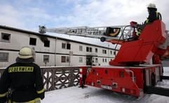 Feuerwehrleute steuern am Samstag (31.12.2005) in Bitterfeld eine Drehleiter zum Brandort des «Motel Bitterfeld». (Foto: dpa)