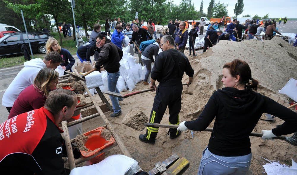 Freiwillige Helfer füllen auf der Halbinsel Pouch Sandsäcke.