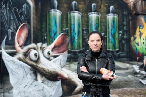 Graffitikünstlerin Claudia Walde, auch MadC genannt, posiert in Halle vor ihrem Kunstwerk "700 wall". Mit dem Kunstwerk hat die 30-Jährige einer vormals öden, rund 100 Meter langen Mauer eines Getreidespeichers einen neuen Anstrich verpasst. (FOTO: DAPD)