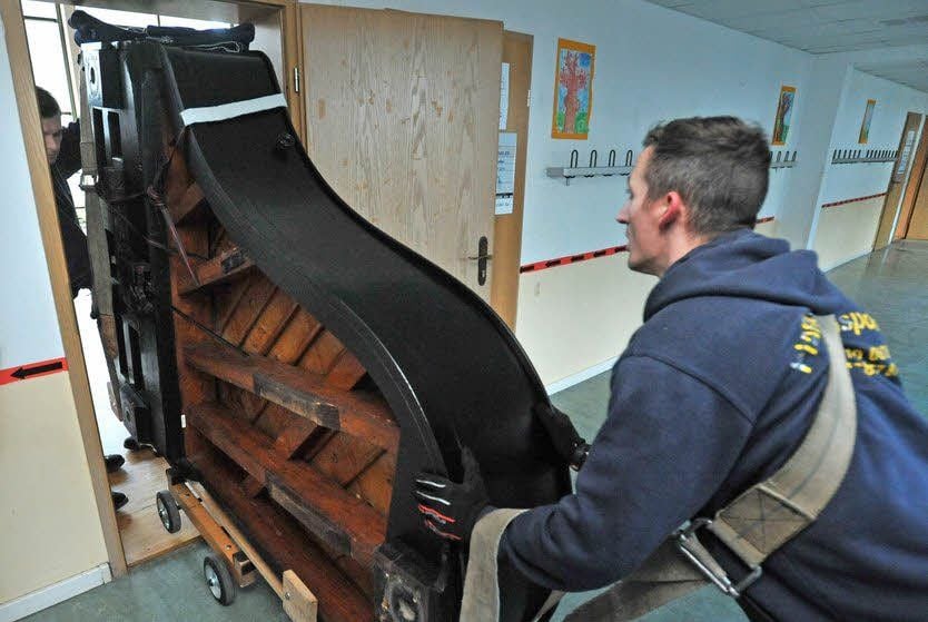 Mit gekonnten Griffen und Techniken haben sie den Flügel innerhalb kurzer Zeit aus dem Transporter ins Schulhaus und über eine Treppe bis zu seinem angestammten Platz in der Aula gebracht.