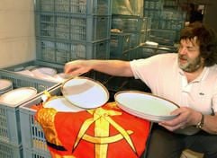 Ladeninhaber Denny Munter steht vor Kisten mit Original-Porzellan aus dem Palast der Republik in einem Antiquitätenladen in Berlin. (Foto: dpa)