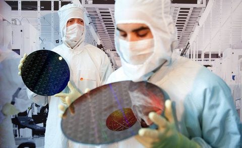 Zwei Mitarbeiter halten während der Grundsteinlegung der «Fab 1 Annex» im Dresdner Werk des Chipherstellers Globalfoundries 300 Millimeter große Chipwafer in den Händen. (FOTO: DPA)