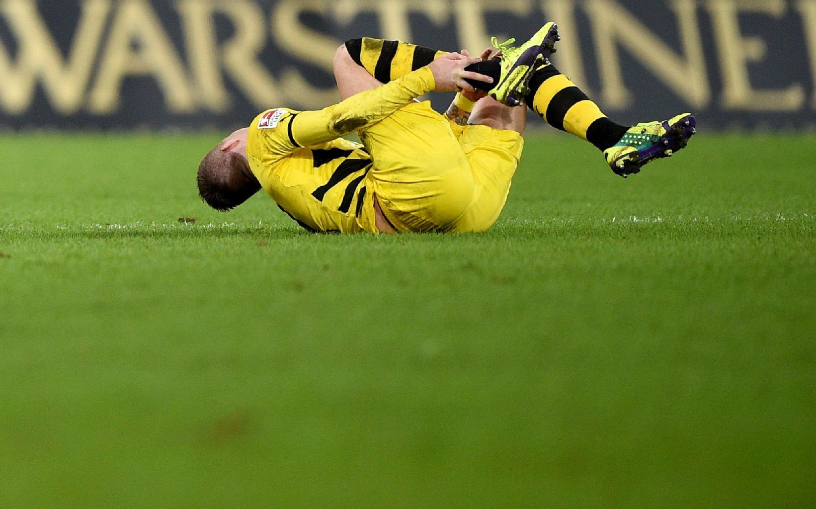 Marco Reus krümmt sich verletzt am Boden.