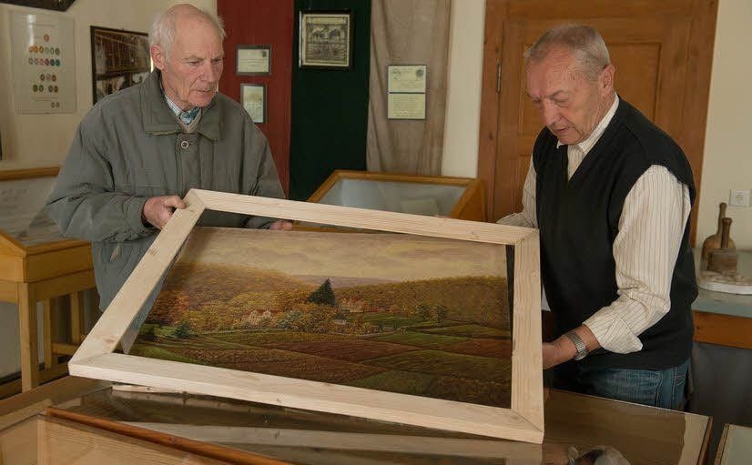 Heinz Mente und Harald Koch (r.) passen den neuen Rahmen für eines der hinzugekommenen Bilder an.