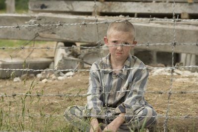 KZ-Häftling Shmuel (Jack Scanlon) sitzt in einer Filmszene aus «Der Junge im gestreiften Pyjama» am Stacheldrahtzaun eines Konzentrationslagers. Trotz aller Umstände freundet sich der Achtjährige mit dem Sohn eines Nazi-Offiziers an, den er immer wieder am Zaun trifft. (FOTO: DPA)