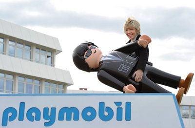 Andrea Schauer, Geschäftsführerin von Playmobil, trägt vor der Firmenzentrale des Spielwarenherstellers in Zirndorf bei Nürnberg (Mittelfranken) eine übergroße Playmobil-Figur. (FOTO: DPA)